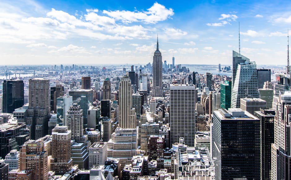 A stunning aerial view of New York City's skyline featuring the iconic Empire State Building under a bright blue sky.